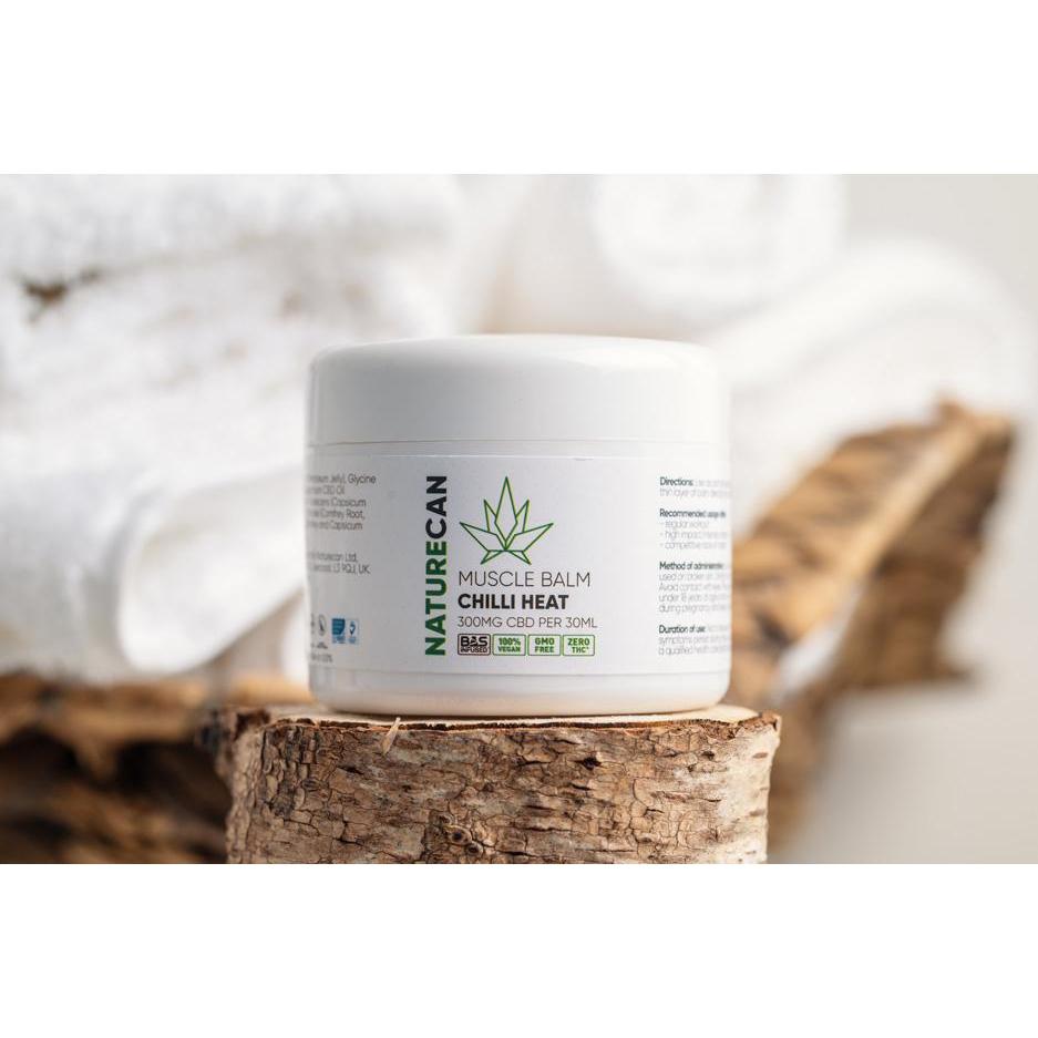 CBD muscle balm tub shown on a log